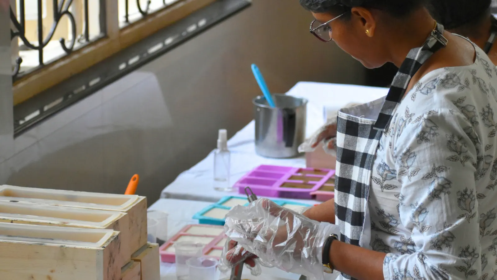 A woman making soap by hand during a skills training session