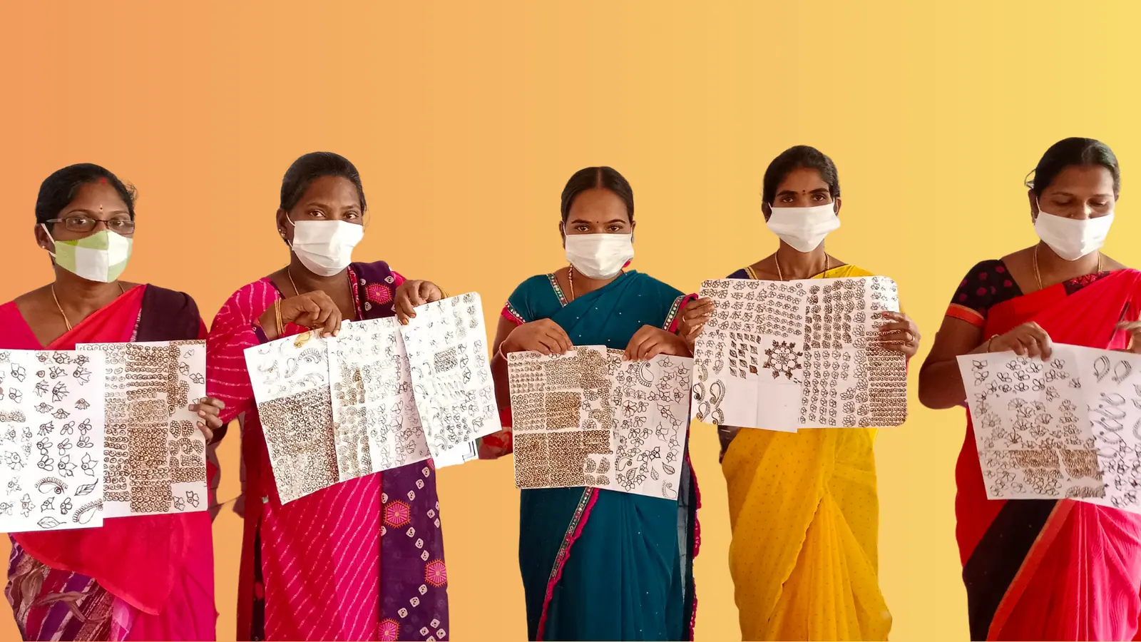 Five women holding up hand-block printed designs against an orange backdrop